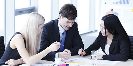 3 working persons at a table 3 working persons at a table