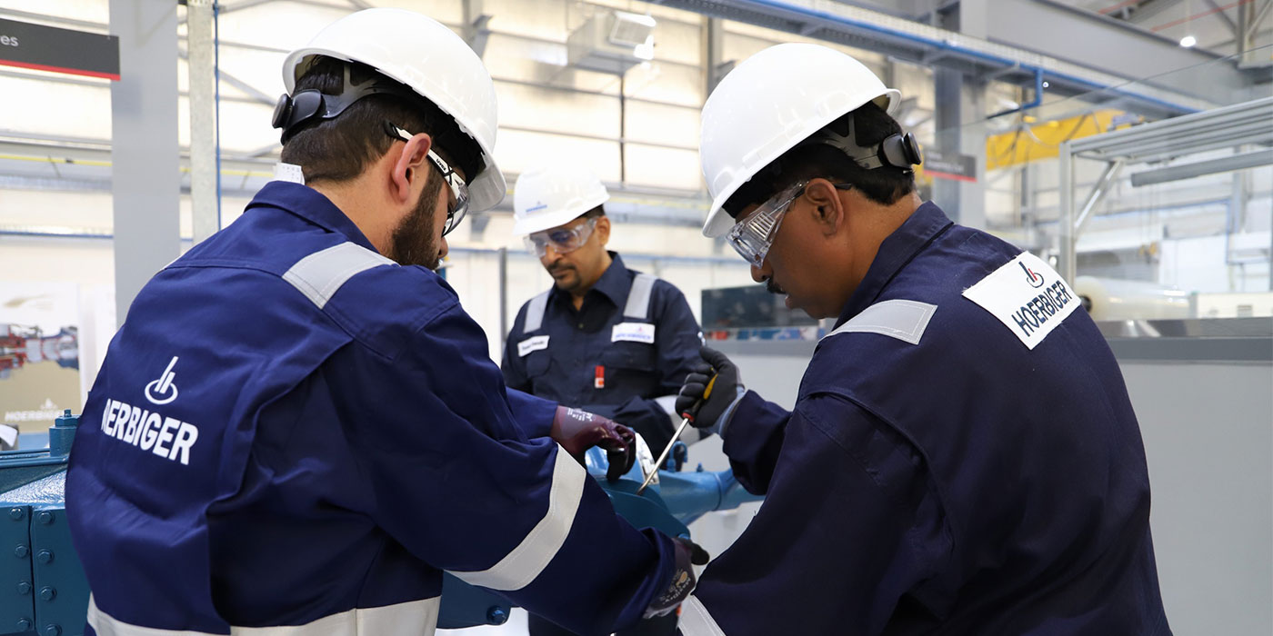 Trainings EIne Schulungsgruppe vor einem Kompressormodell